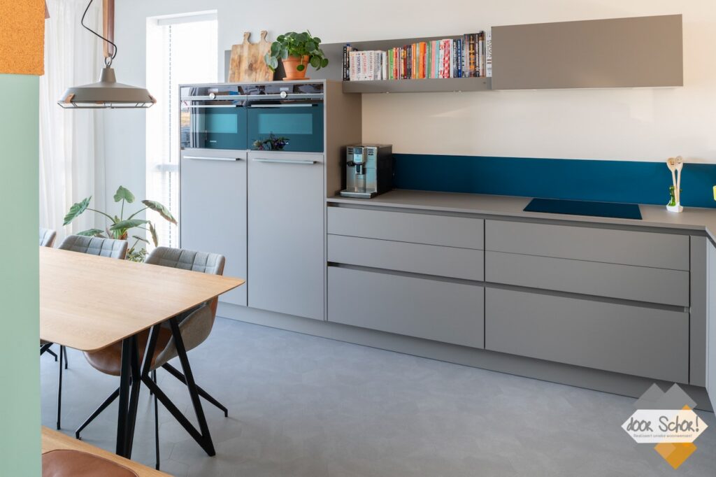 Mat grijze keuken met een greeploos design vanuit een andere hoek