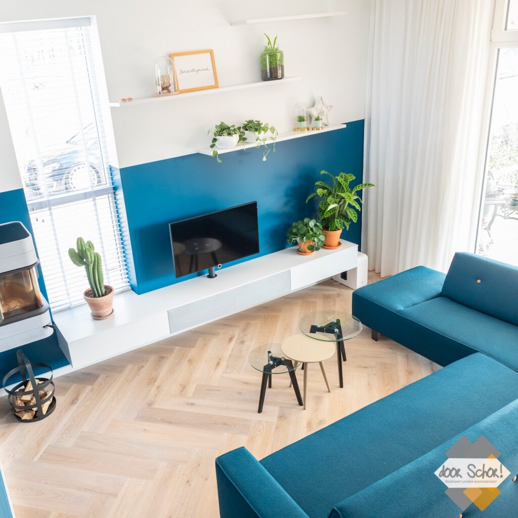 Petrol blauw op de wand en ook een blauwe bank